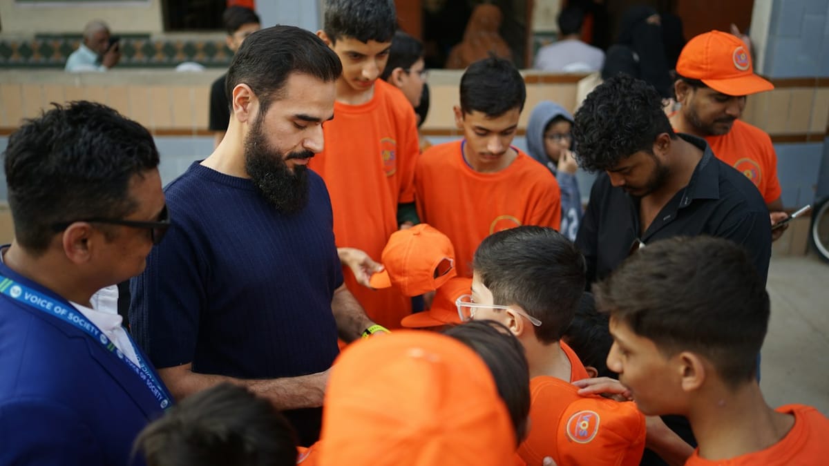 Volunteers handing out orange caps to young people